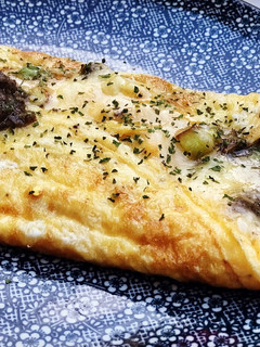 Una foto de Tortilla de queso y ajetes con trufa y un toque picante 🌶😏