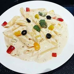 A picture of Penne Pasta in white sauce.