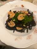 Tagliolini al nero di seppia gamberi grigliati pesto di senape e pinoli tostati