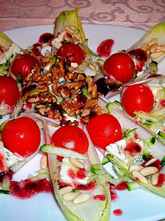Una foto de Pétalos de endivias con queso gorgonzola, tomatitos cherry y frutos secos aliñadas con mermelada de fresas