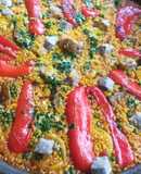 Arroz de pescado con alcachofas y pimiento rojo en paella
