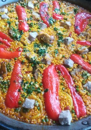 Una foto de Arroz de pescado con alcachofas y pimiento rojo en paella