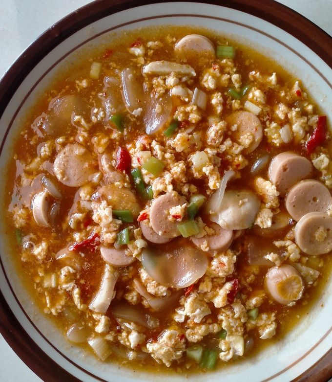 Semangkuk seblak pedas khas Indonesia dengan kerupuk, ceker, dan kuah merah kental yang menggugah selera