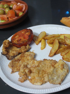 Una foto de Solomillo rebozado con patatas y tomate