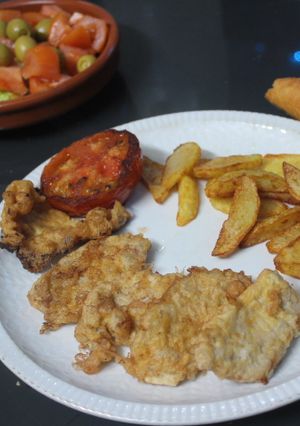 Una foto de Solomillo rebozado con patatas y tomate