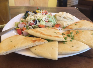 A picture of Mediterranean salad with pita bread.