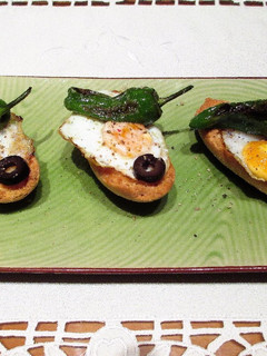 Una foto de Panecillos crujientes con huevos de codorniz y pimientos de Padrón