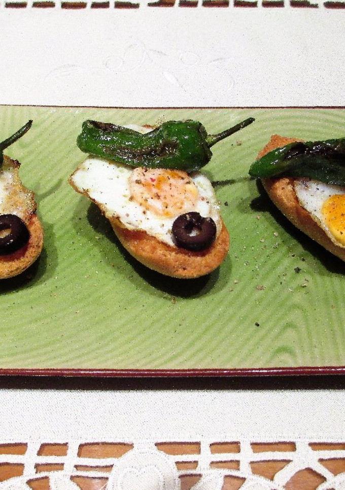 Una foto de Panecillos crujientes con huevos de codorniz y pimientos de Padrón