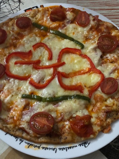 Una foto de Pizza de jamón, lacón y queso havarti con pimientos y tomate cherry