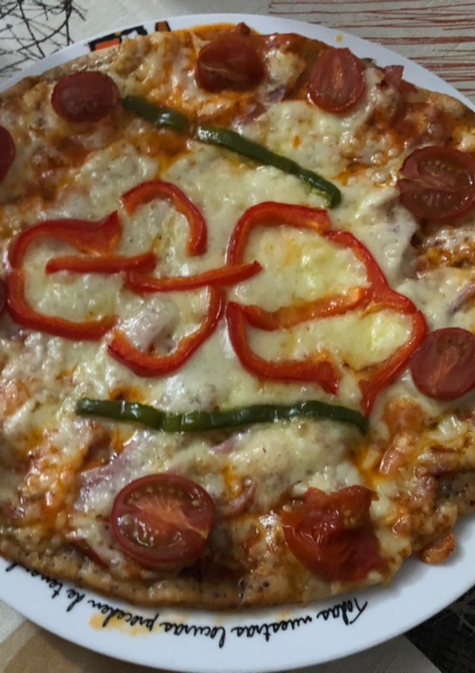 Una foto de Pizza de jamón, lacón y queso havarti con pimientos y tomate cherry
