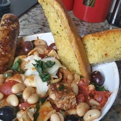 A picture of Grilled Sausage and Cannellini Beans Puttanesca w/ Garlic Bread.