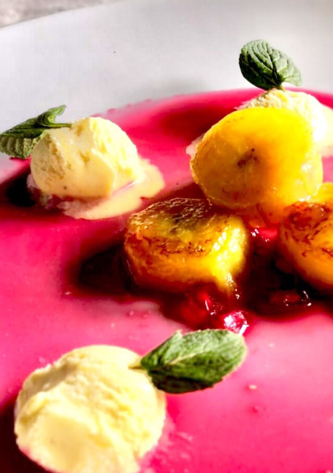 Una foto de Plátano flambé con granada y helado