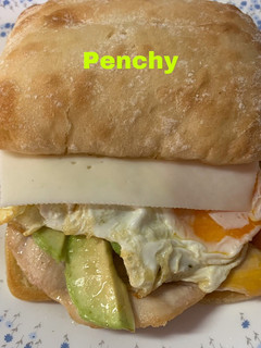 Una foto de Bocata de pan de cristal, con aguacate, huevo, pollo, y queso de cabra