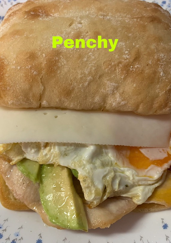 Una foto de Bocata de pan de cristal, con aguacate, huevo, pollo, y queso de cabra