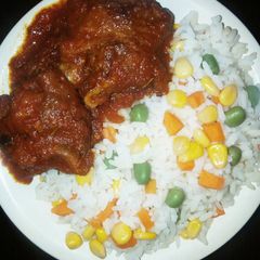 Boiled rice with vegetables,tomato sauce and chicken A picture of Boiled rice with vegetables,tomato sauce and chicken.