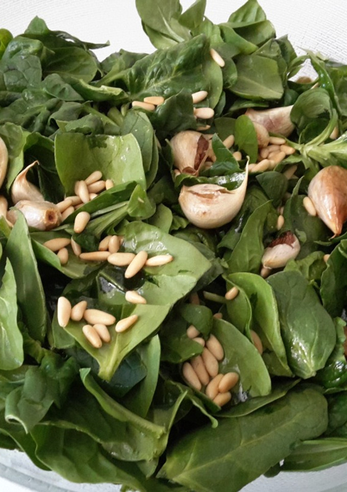 Una foto de Ensalada de espinaca y canónigos con ajo y piñones