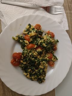 Una foto de Revuelto de espinacas, queso y tomates cherrys