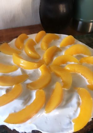 Una foto de Bizcochuelo relleno con cobertura de merengue y duraznos