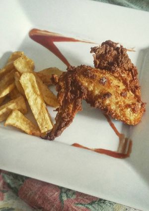 Una foto de Alitas estilo kentucky con papas fritas y salsa barbacoa casera