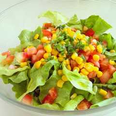 Una foto de Ensalada de maíz tierno, tomates y lechugas