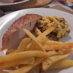 Una foto de Chuleta de Cerdo con Revuelto de Arvejas y Fritas