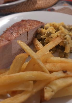 Una foto de Chuleta de Cerdo con Revuelto de Arvejas y Fritas