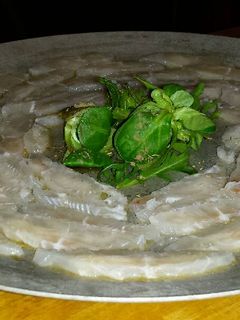 Una foto de Sashimi de panga con rúcula y canónigos