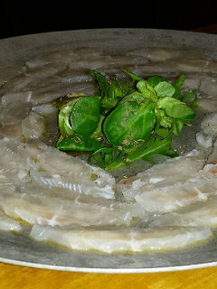 Una foto de Sashimi de panga con rúcula y canónigos