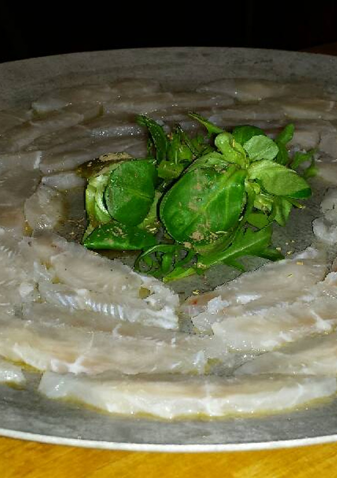 Una foto de Sashimi de panga con rúcula y canónigos