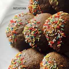 A picture of Chocolate cookies partly covered in Sprinkles.