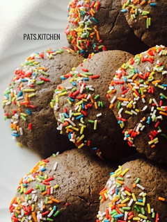 A picture of Chocolate cookies partly covered in Sprinkles.