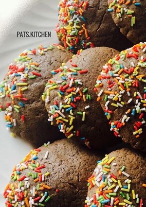 A picture of Chocolate cookies partly covered in Sprinkles.
