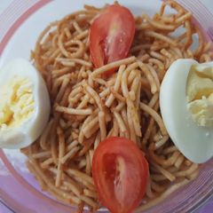 A picture of Spagetti with egg and fresh tomatoes.