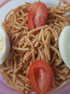 A picture of Spagetti with egg and fresh tomatoes.