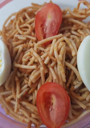 A picture of Spagetti with egg and fresh tomatoes.