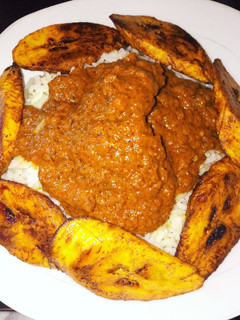 A picture of Groundnut stew with rice and plantains.