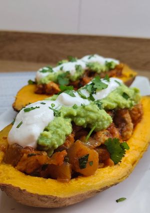 Una foto de Boniato relleno de pollo con aguacate y salsa de yogur