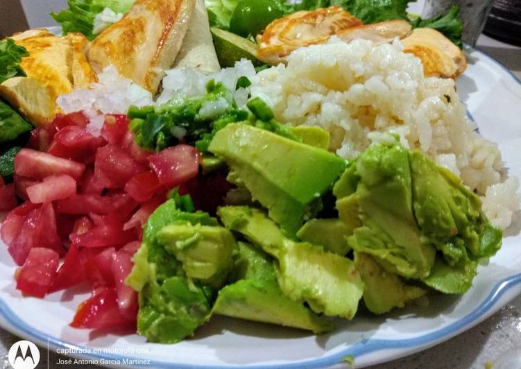 Pechuga de pollo volador sobre cama de verdura multicolor