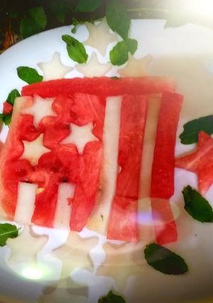 A picture of Red yellow melon dessert in the shape of a flag.