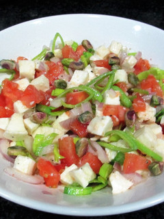 Una foto de Ensalada de mozzarella con tomate, cebolla y pistachos