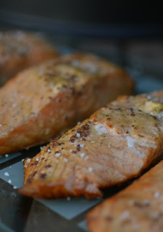 Una foto de Salmón preparado en horno ahumador macerado en mostaza antigua y zumo de mandarina