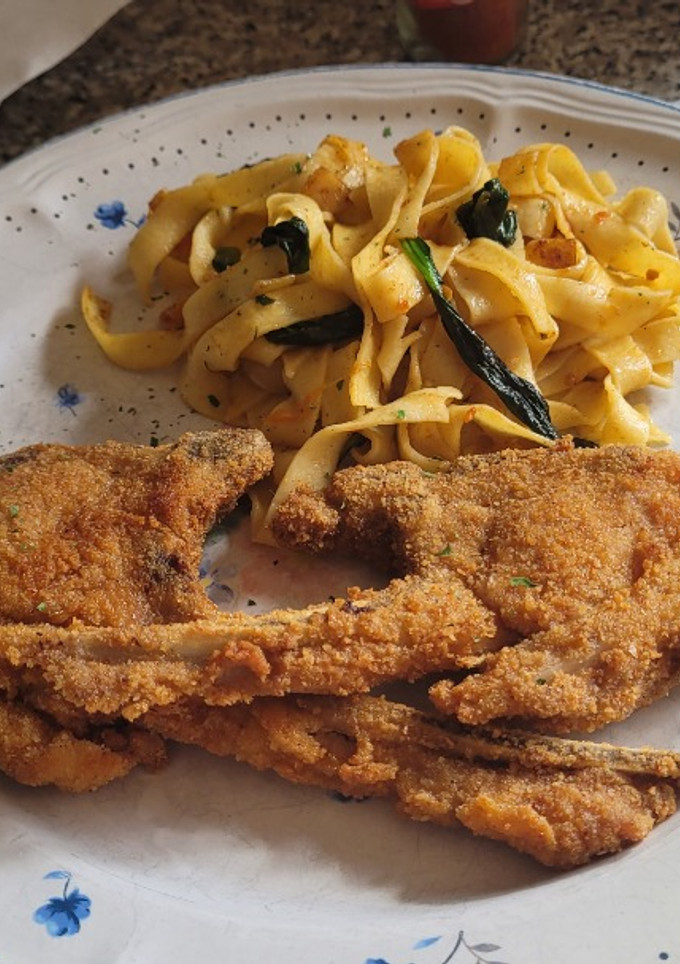 Una foto de Chuletas de cordero rebozadas con pasta y espinacas