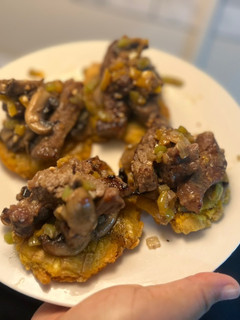 Una foto de Tostones con Ny strip en vegetales salteados