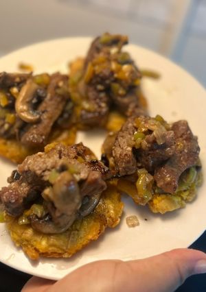 Una foto de Tostones con Ny strip en vegetales salteados