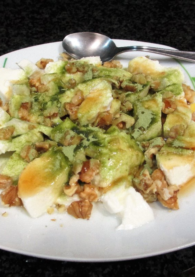 Una foto de Bola de mozzarella con nueces y té matcha bañadas con sirope de agave