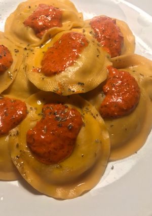 Una foto de Tortelloni de berenjena, tomate y mozzarella, con salsita de pimientos rojos