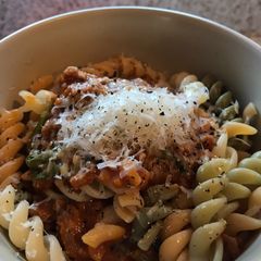 A picture of Pasta w butternut squash sauce, sausage and spinach.