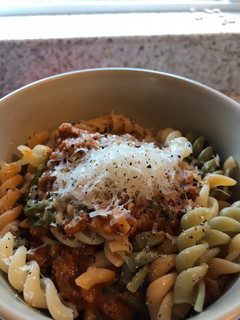 A picture of Pasta w butternut squash sauce, sausage and spinach.