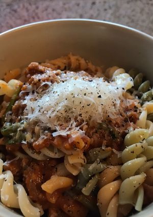 A picture of Pasta w butternut squash sauce, sausage and spinach.