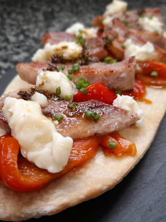 Una foto de Coca de secreto a la plancha, chimichurri, pimiento y gorgonzola